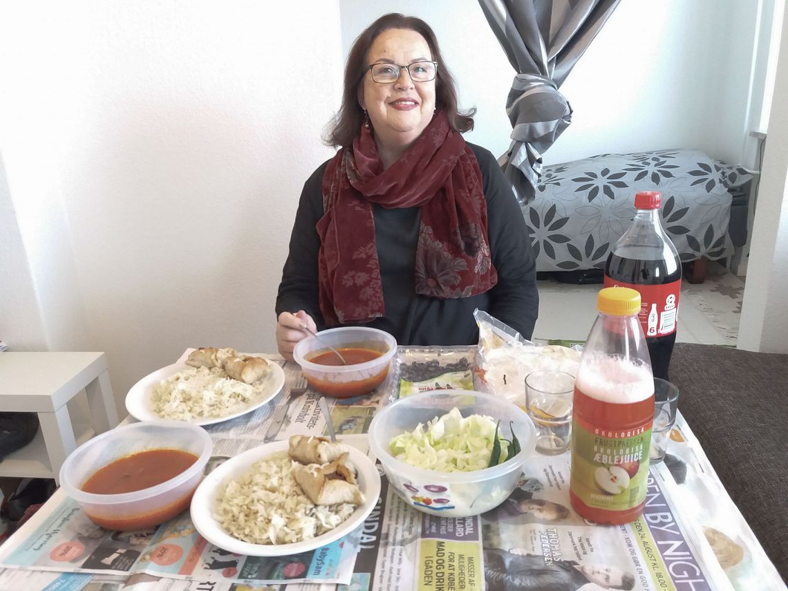 A woman sitting at a table with food on it. 