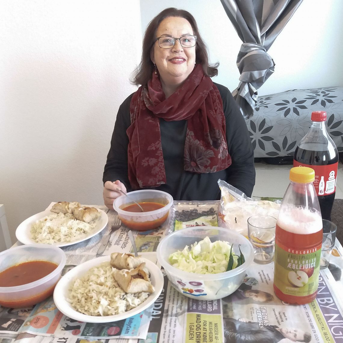 A woman sitting at a table with food on it. 