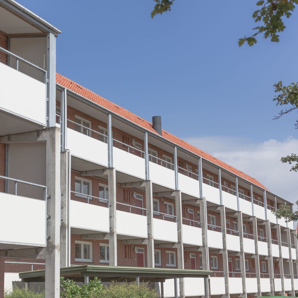 Apartments with white balconies in a red brick building