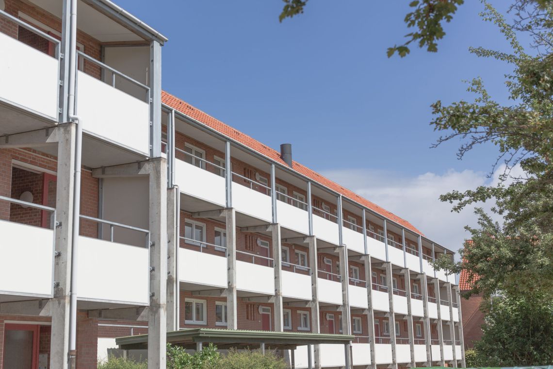 Apartments with white balconies in a red brick building