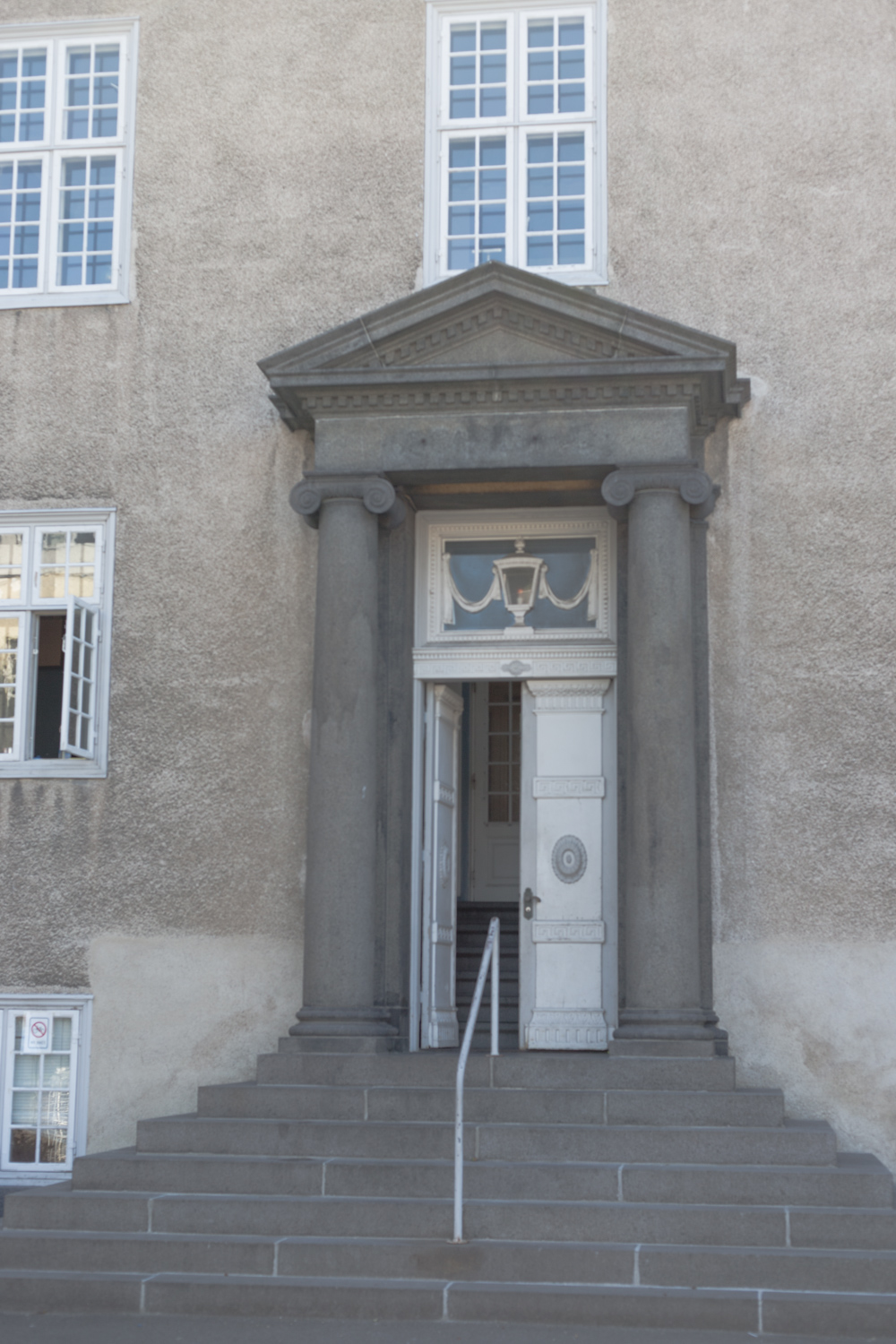 A staircase and a white door in a big building