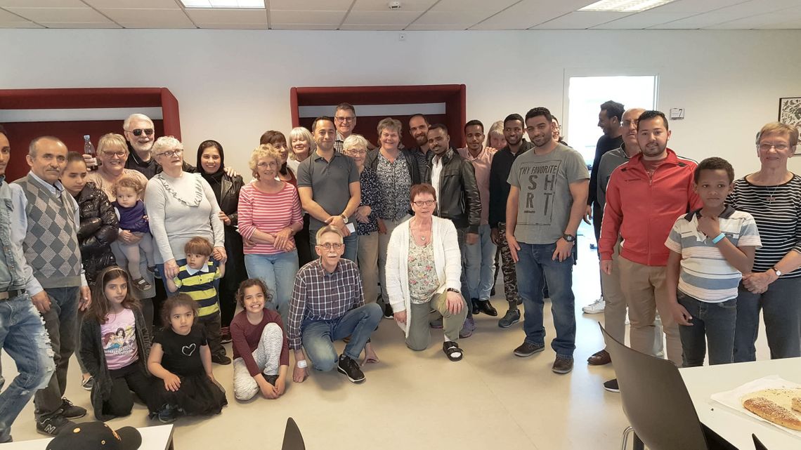 A lot of people standing in a half cirkel facing the camera