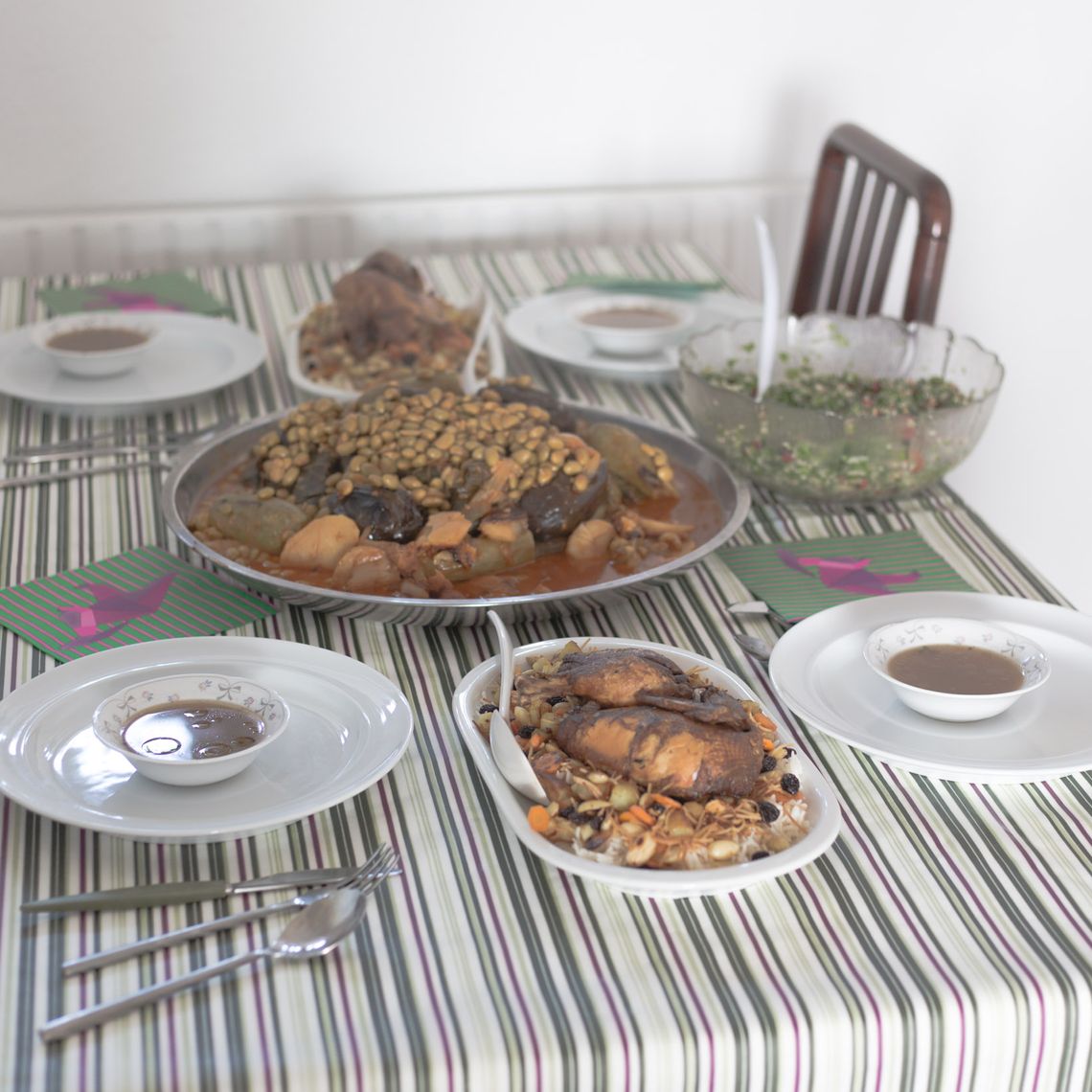 A table with four chairs and plates with food