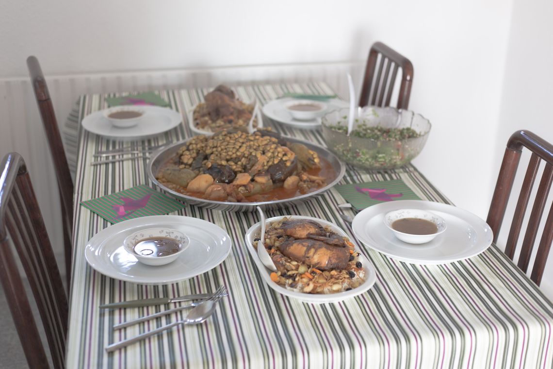 A table with four chairs and plates with food