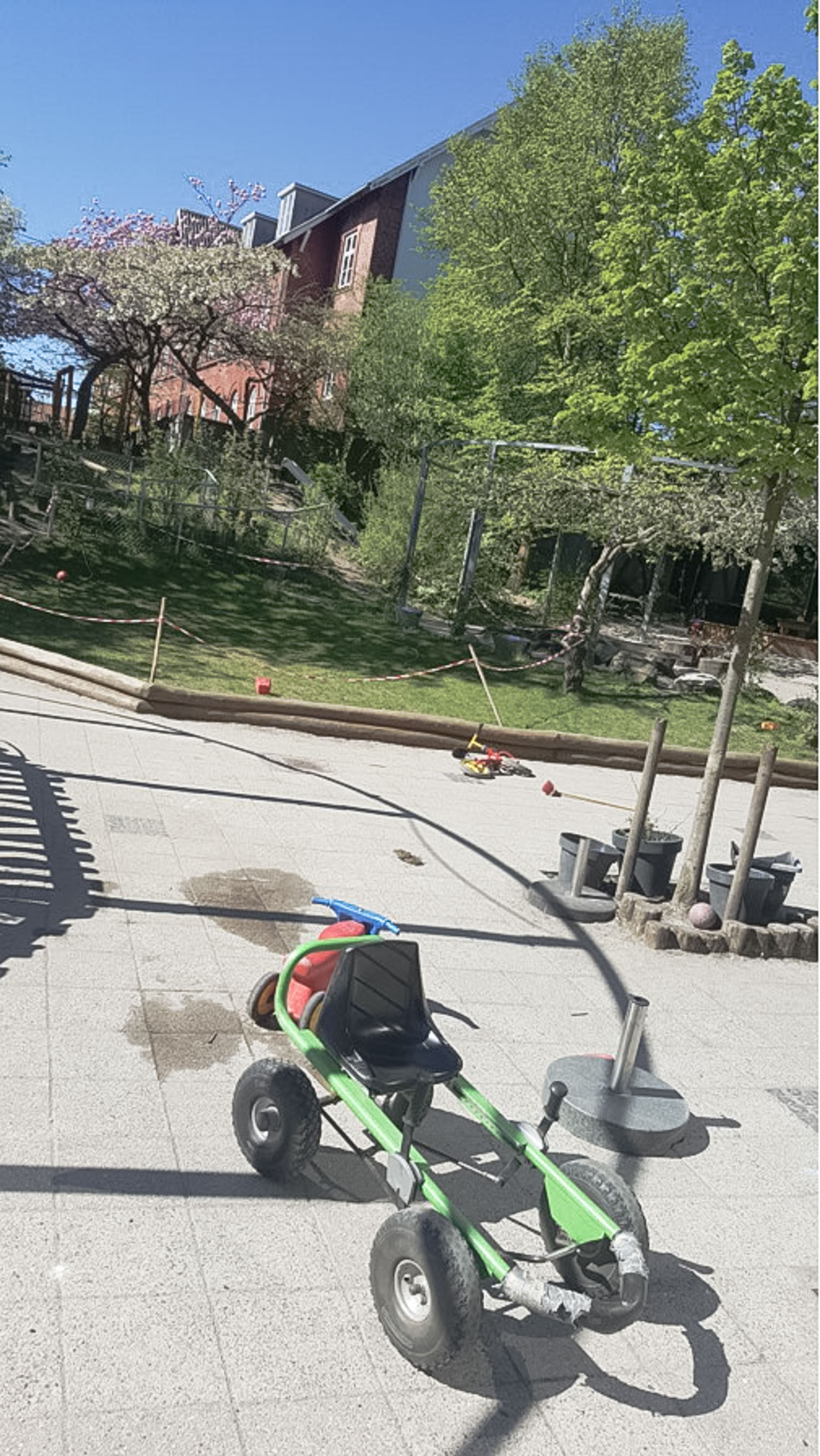 An outside playground with a bike and plants.